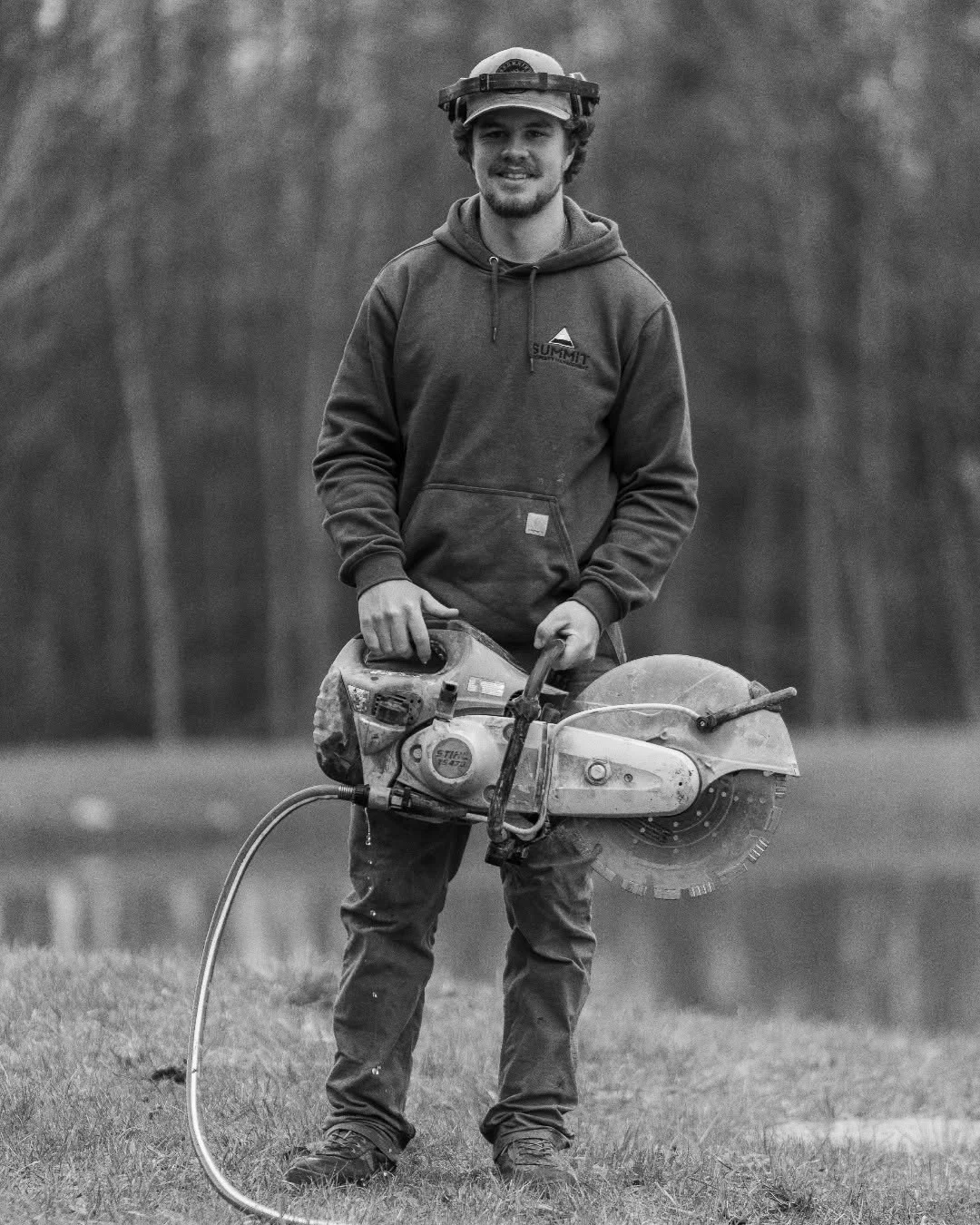 Ty Garon stands outdoors holding a large masonry saw.