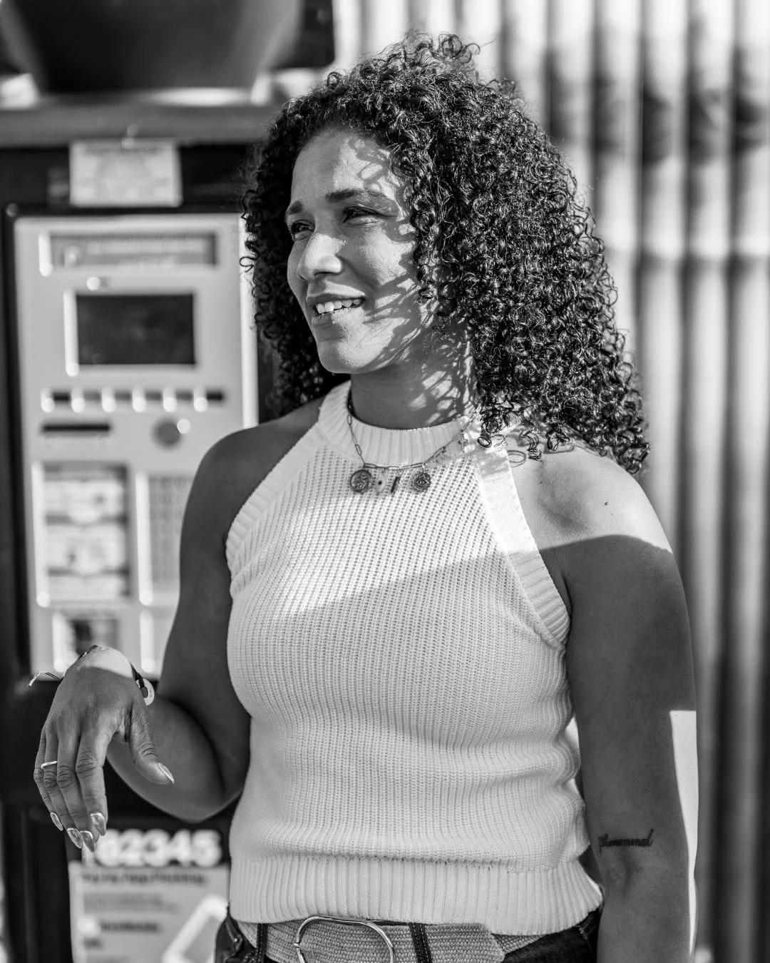 A smiling woman stands beside a payment terminal at a bike shop.