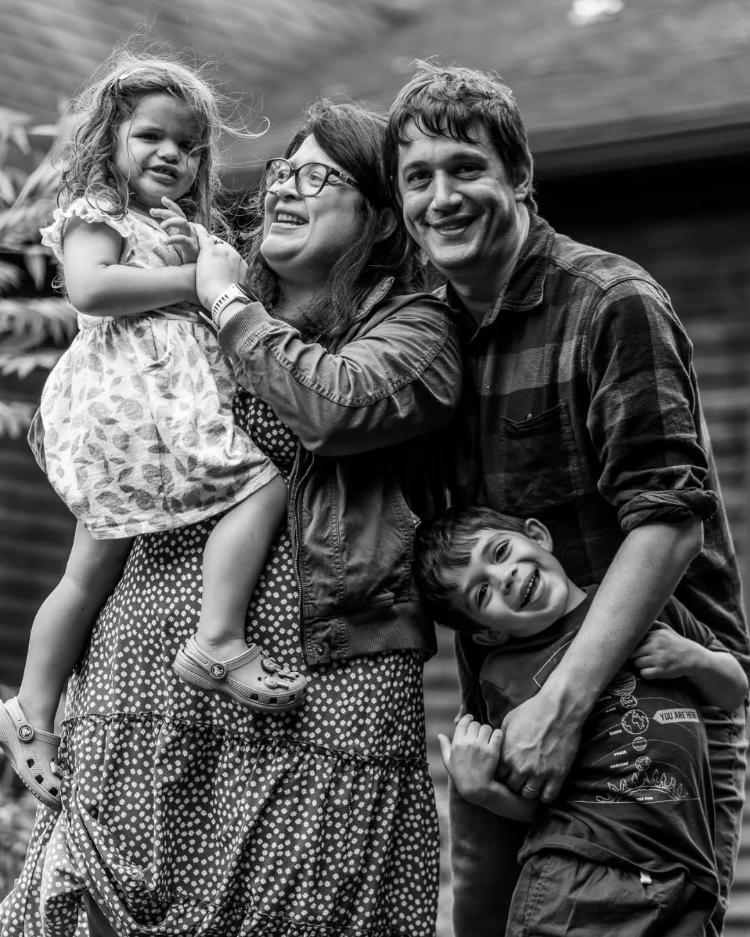 A couple poses outdoors with their daughter and son.