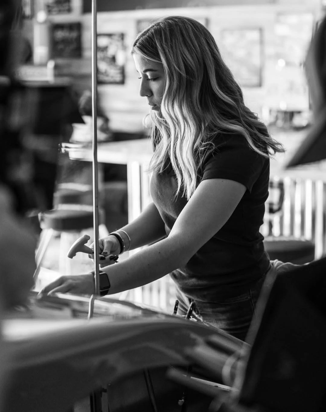 Taylor Hoar works with a hand tool on a stock car in the race shop.