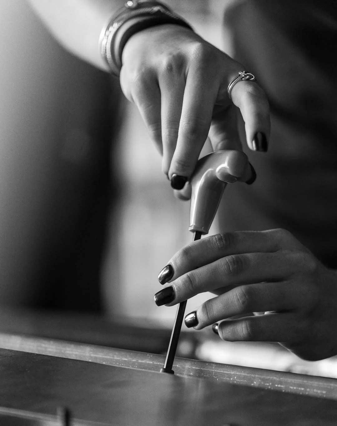 Close-up of Taylor Hoar’s hands turning a T-handle tool on a race car.