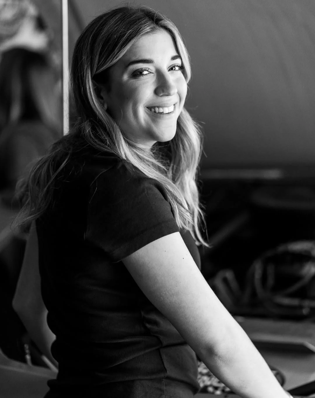 Taylor Hoar looks back over her shoulder while seated in the race shop.