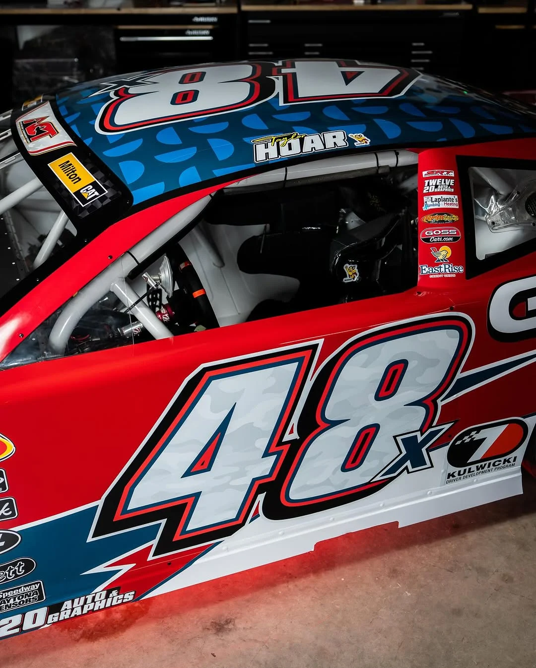 Close view of the red No. 48x car’s door, roof number, cockpit, and sponsor decals.