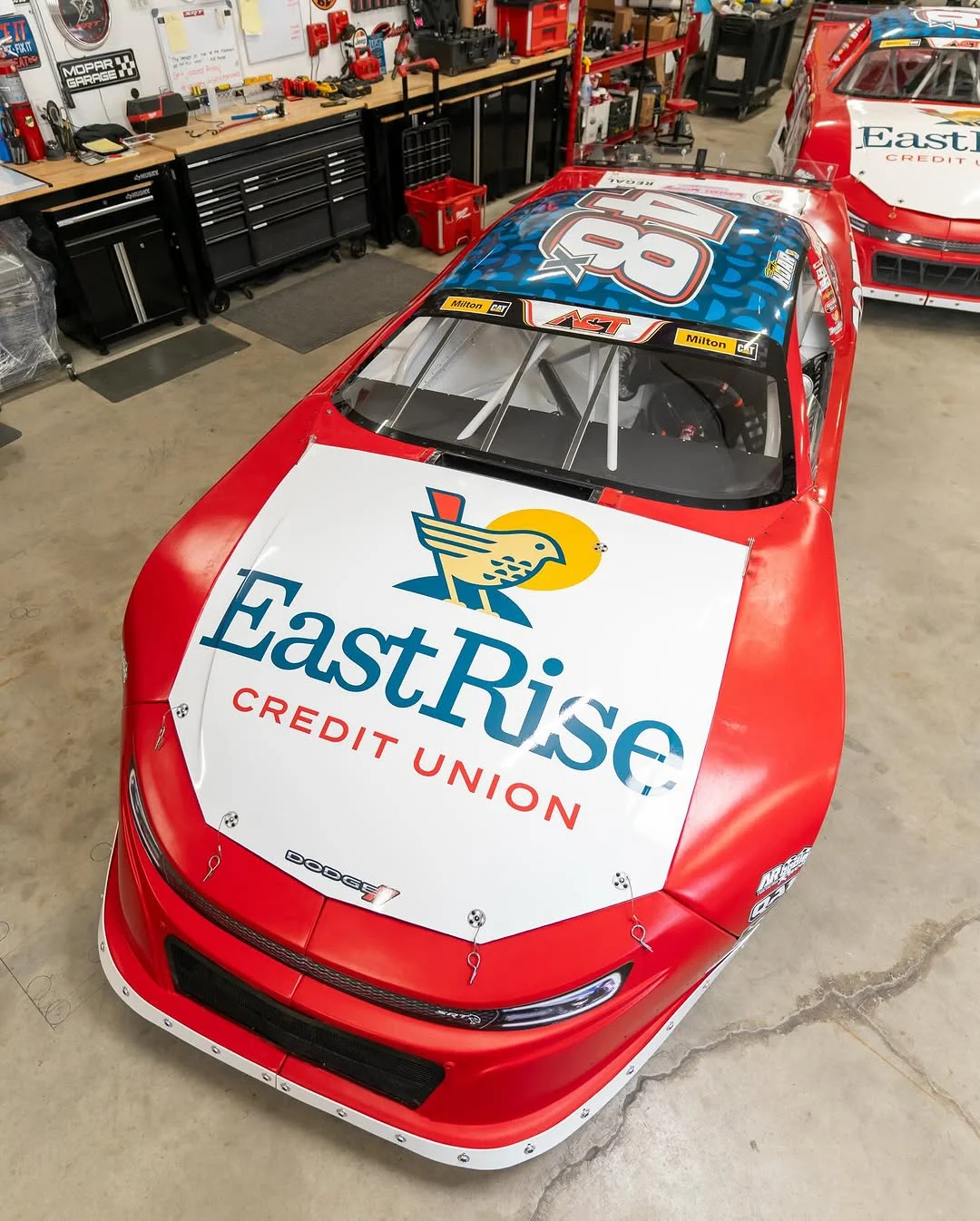 Taylor Hoar’s red No. 48x car with an EastRise hood logo sits inside the race shop.