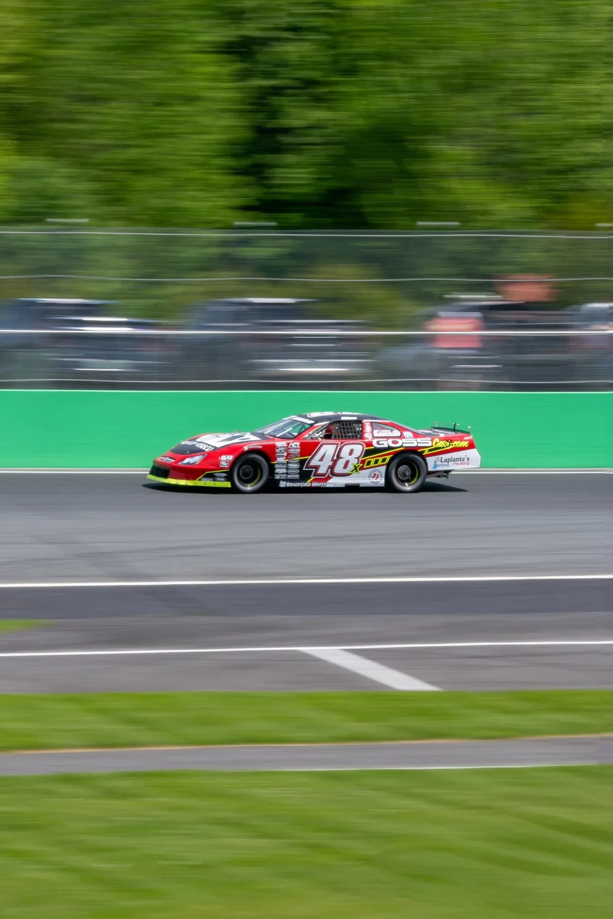 Taylor Hoar’s red No. 48x stock car races past the green retaining wall.