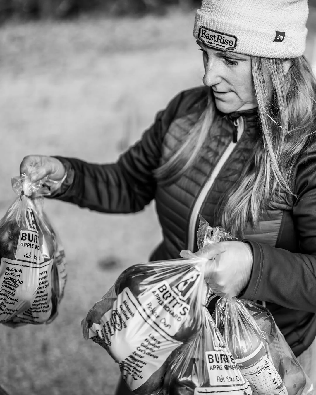 A volunteer carries several bags of vegetables.
