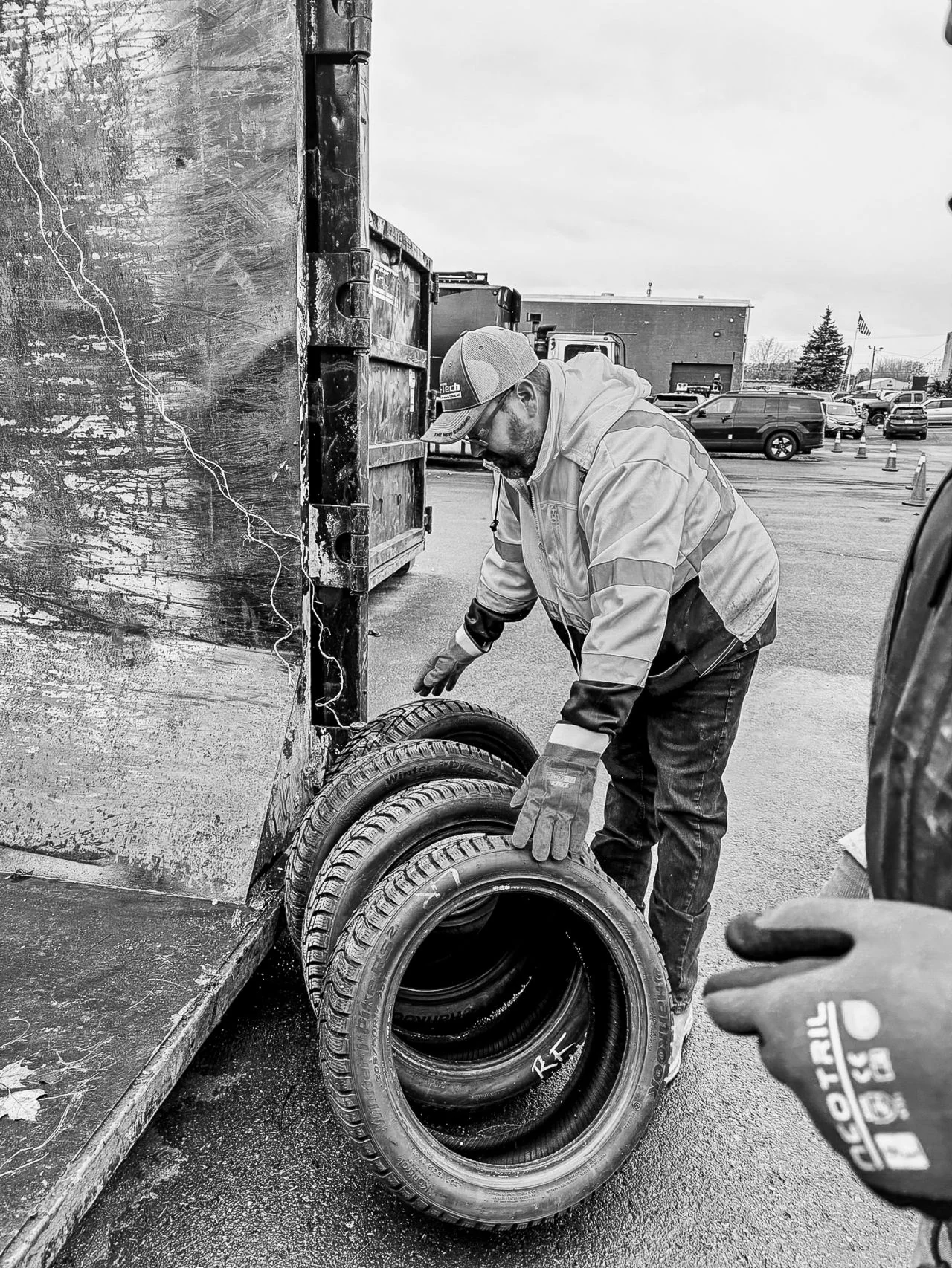 A volunteer lifts a tire from an open trailer during the donation drive.