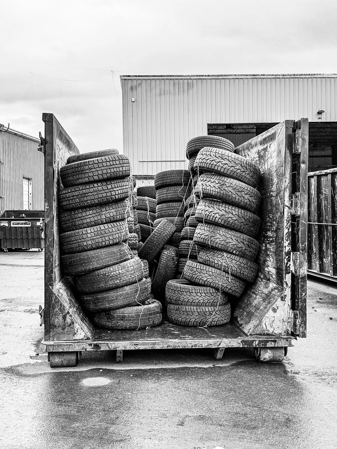 Stacks of donated tires fill an open truck container.