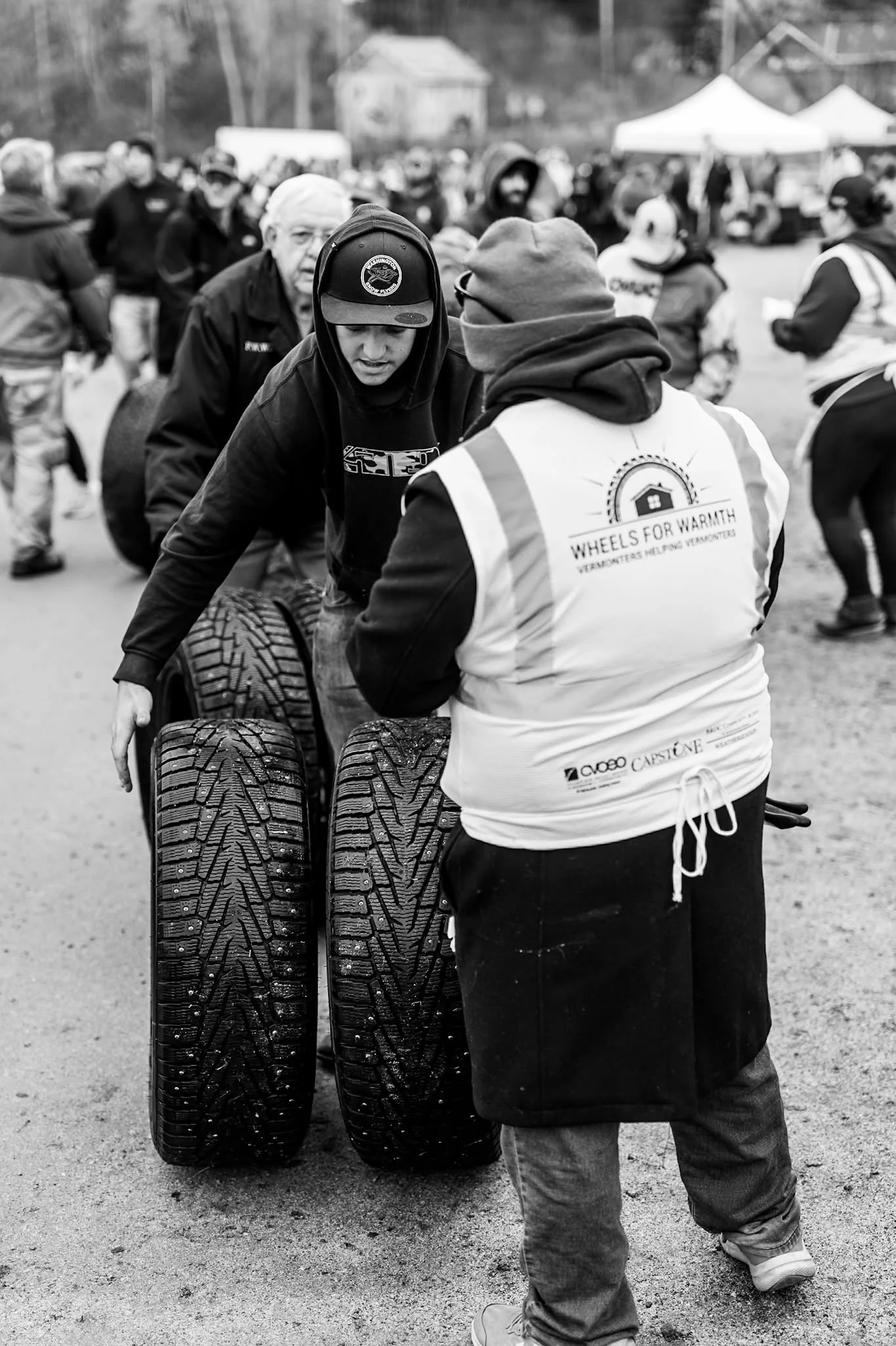 Volunteers push a stack of tires on a hand truck at Wheels for Warmth.