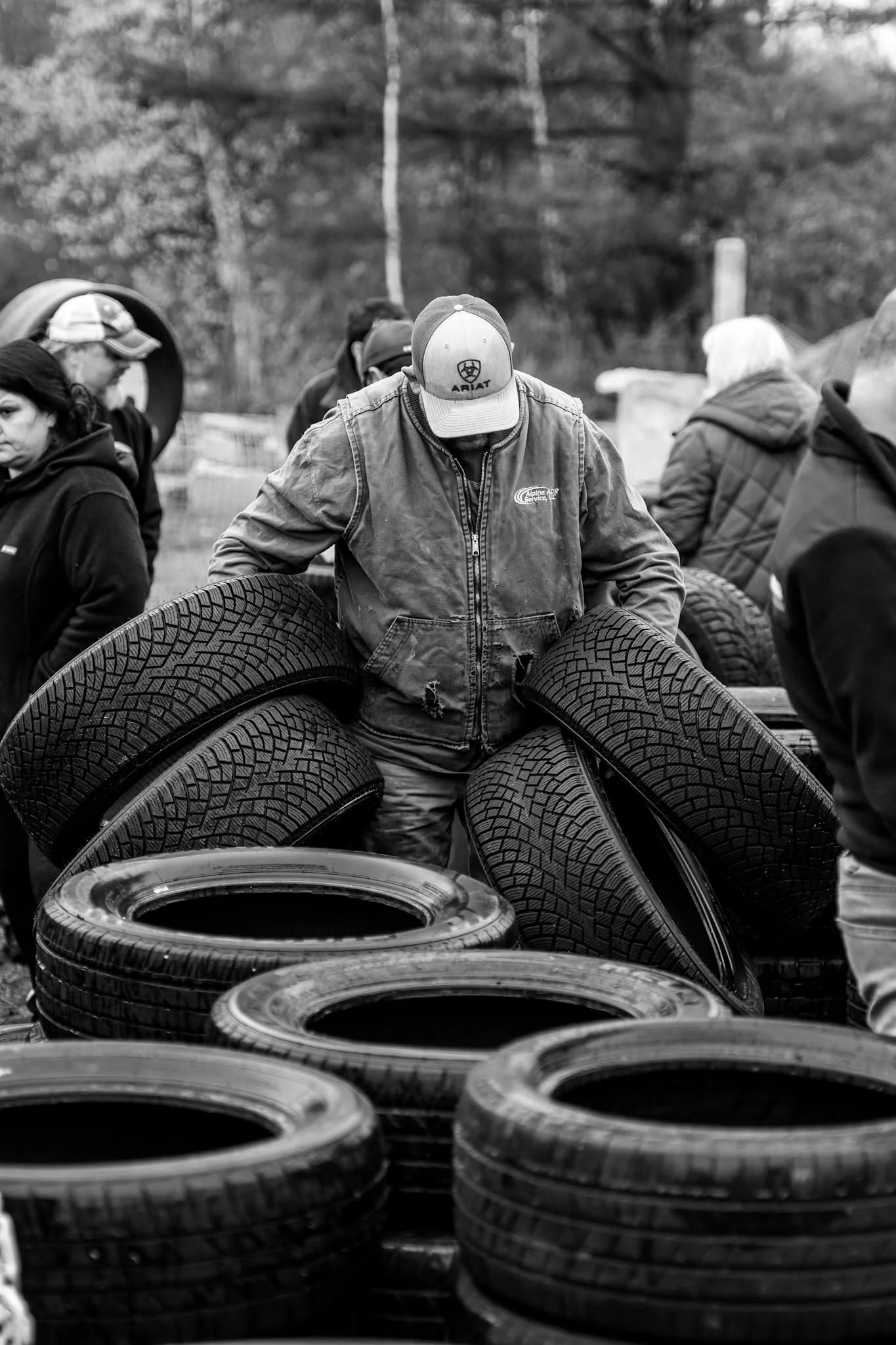 Two volunteers pose together while holding tires at Wheels for Warmth.