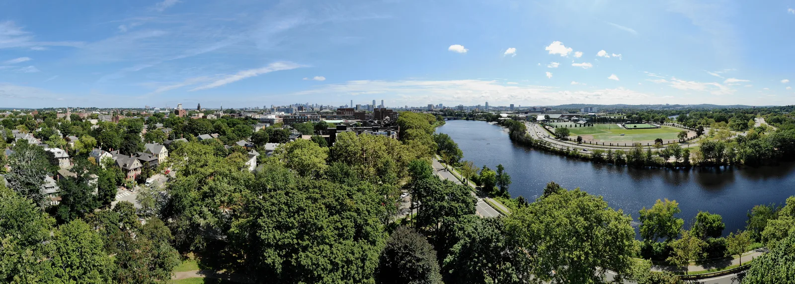 Aerial panorama of tree-lined city neighborhoods surrounding a winding river