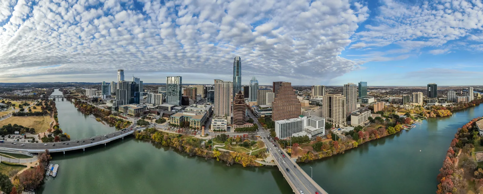 Panoramic aerial view of downtown Austin and the Colorado River beneath rippled clouds