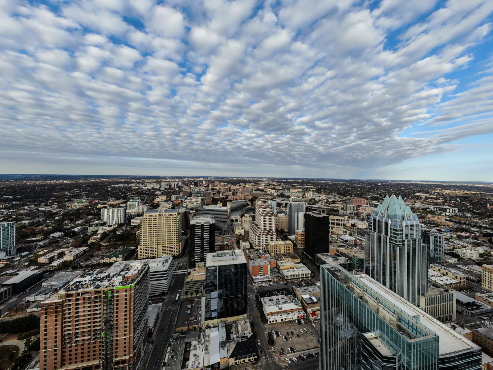 Downtown Austin skyline viewed from above beneath a broad field of rippled clouds