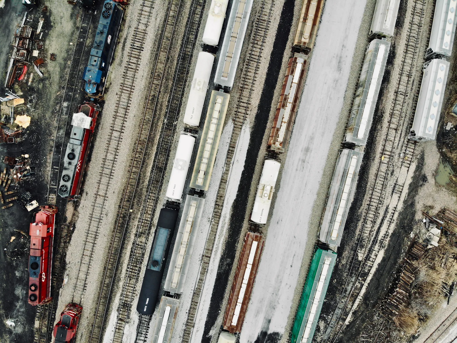 Top-down view of parallel rail tracks filled with freight and passenger cars