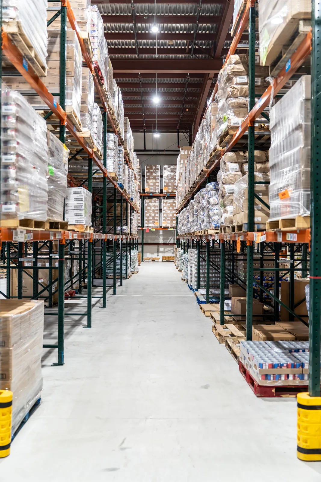 Warehouse aisle with tall metal shelving filled with boxed goods