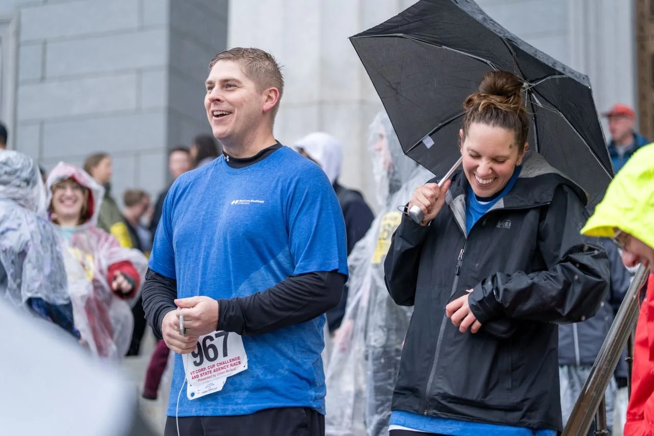 Two Corporate Cup participants walk together in the rain.