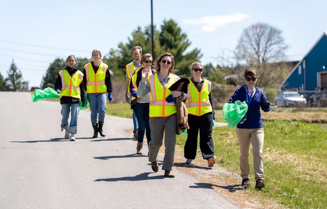 A group of Green Up Day volunteers walks along a rural road.